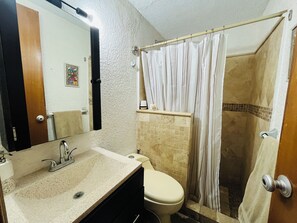 Ein Badezimmer mit Waschbecken, Toilette und Duschbereich.