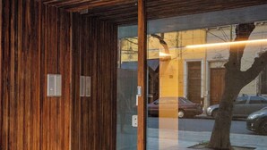 A modern building entrance with wooden paneling and a glass door.