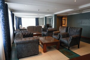 A spacious living room with a sofa set, armchairs, and a coffee table.