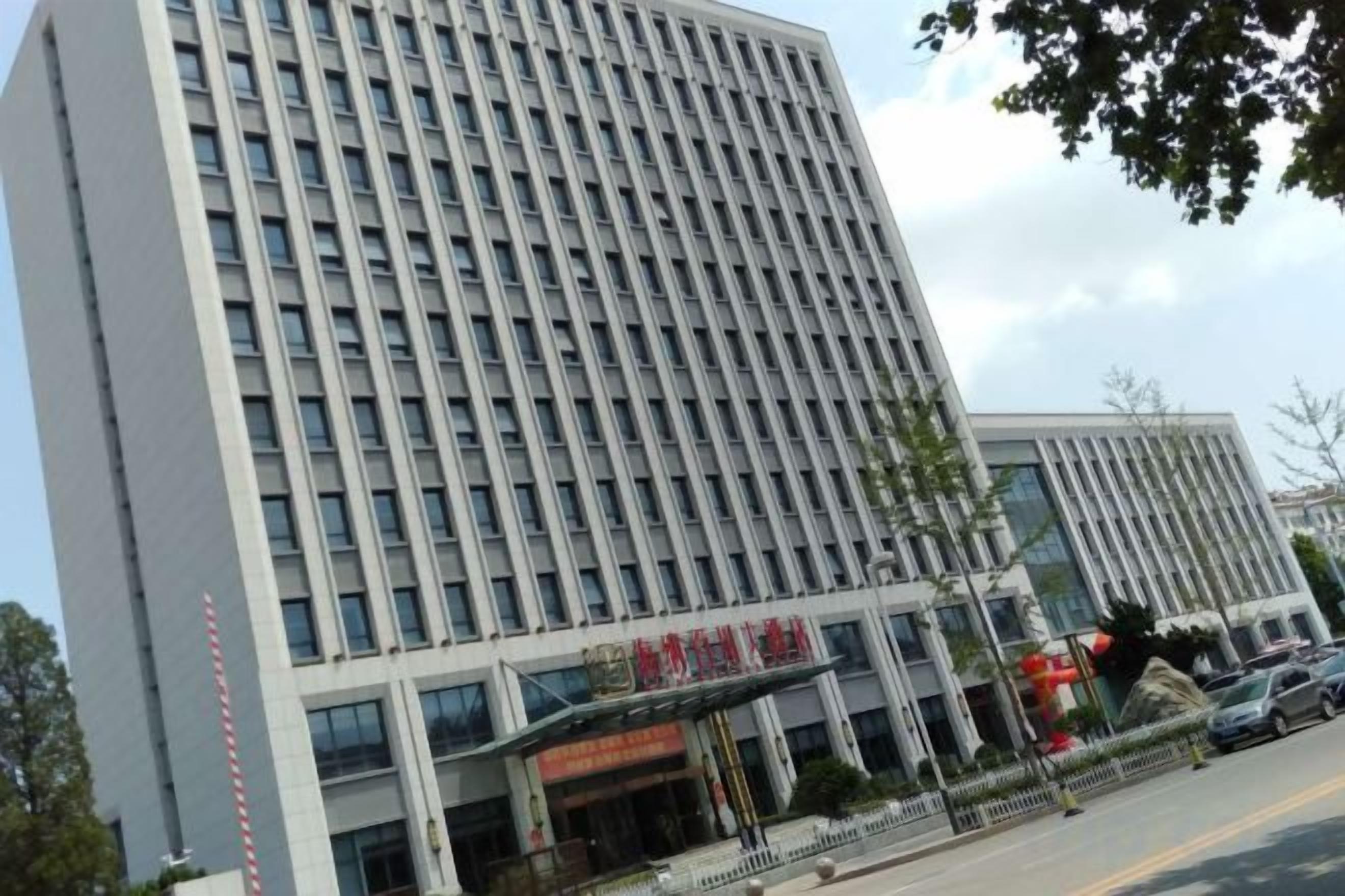 Een meerhoog gebouw met een opvallende ingang en borden.