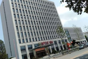 Een meerhoog gebouw met een opvallende ingang en borden.