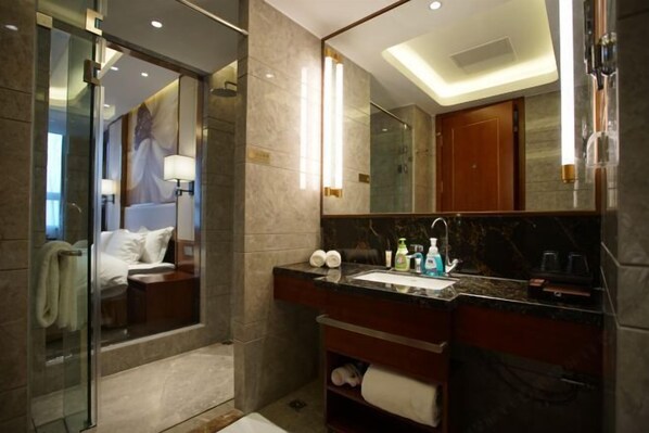 A modern bathroom with a glass shower enclosure, a marble countertop, and a large mirror. - Qingdao Haina Baichuan Hotel (Pingdu)