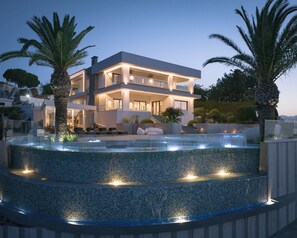 A modern two-story house with a pool, outdoor seating, and palm trees. - Villa Kalliston - 4000m2 of Elevated Living (Rethymno)