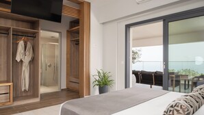 A modern bedroom with a large bed, a walk-in closet, a potted plant, and a sliding glass door to a balcony. - Villa Kalliston - 4000m2 of Elevated Living (Rethymno)