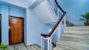 A staircase with marble steps and a wooden handrail leading to a landing. - Hotel Aashraya Home Pvt. Ltd.  (Kathmandu)