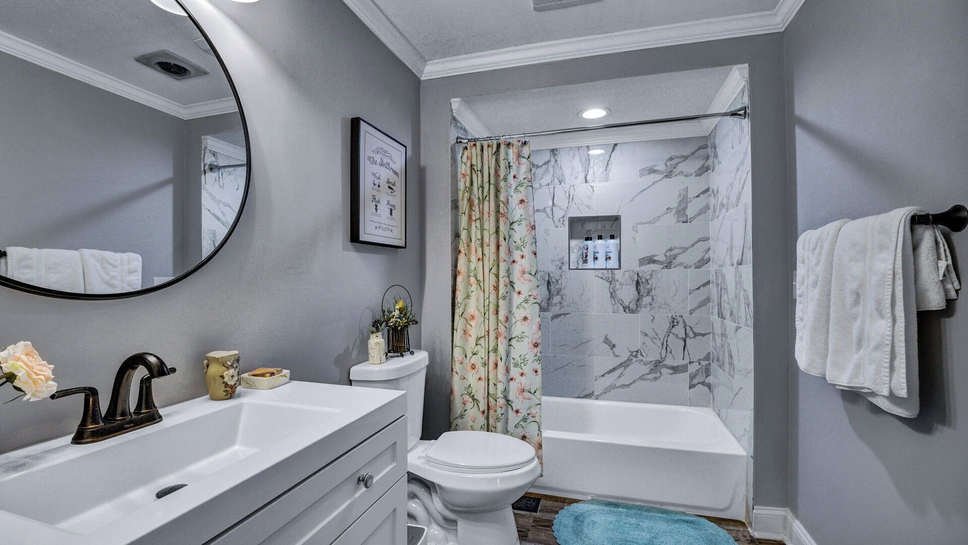 A bathroom with a white sink, a toilet, a bathtub, and a shower curtain.