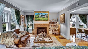 A spacious living room with a fireplace, a comfortable sofa, a coffee table, and a bookshelf. - Live in sophistication and elegance in your VRBO home (Rochester)