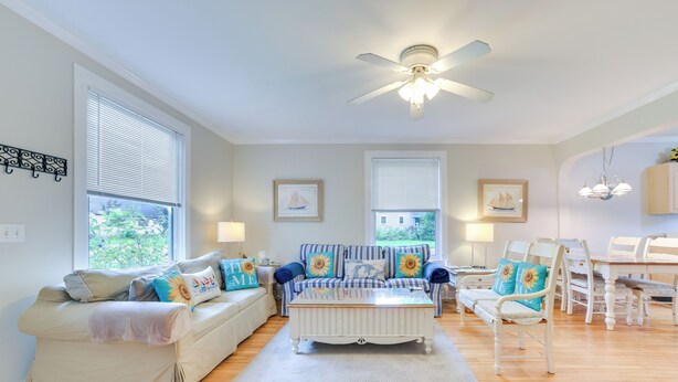 A living room with a sofa, a coffee table, and a dining table with chairs. - Walk to Lake Michigan: Pet-Friendly Charlevoix Gem (Charlevoix)