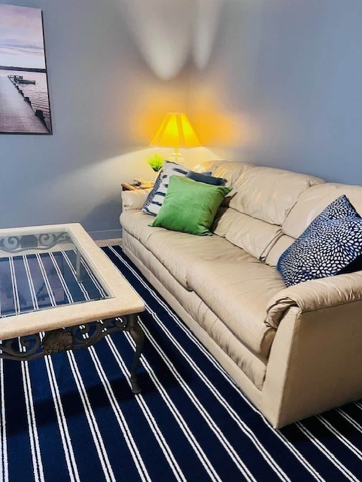 A living room with a sofa, a coffee table, and a lamp.