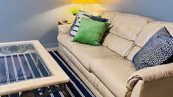 A living room with a sofa, a coffee table, and a lamp.