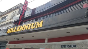 Un letrero de hotel con el nombre "MILLENNIUM" y un cartel de entrada debajo.