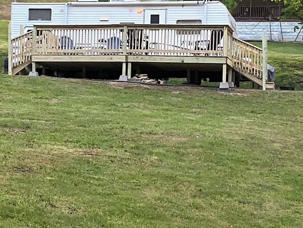 A mobile home with a wooden deck and a ramp leading to the entrance. - Cozy RV, New River and hiking trails nearby. Peaceful and quiet deer visits freq (Fayetteville)