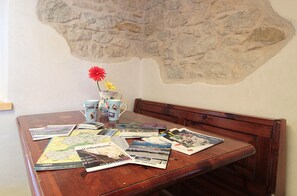A wooden table with travel brochures and a vase with flowers. - Baita Tersilia Near Lake And Mountain  (Borgo Valbelluna)