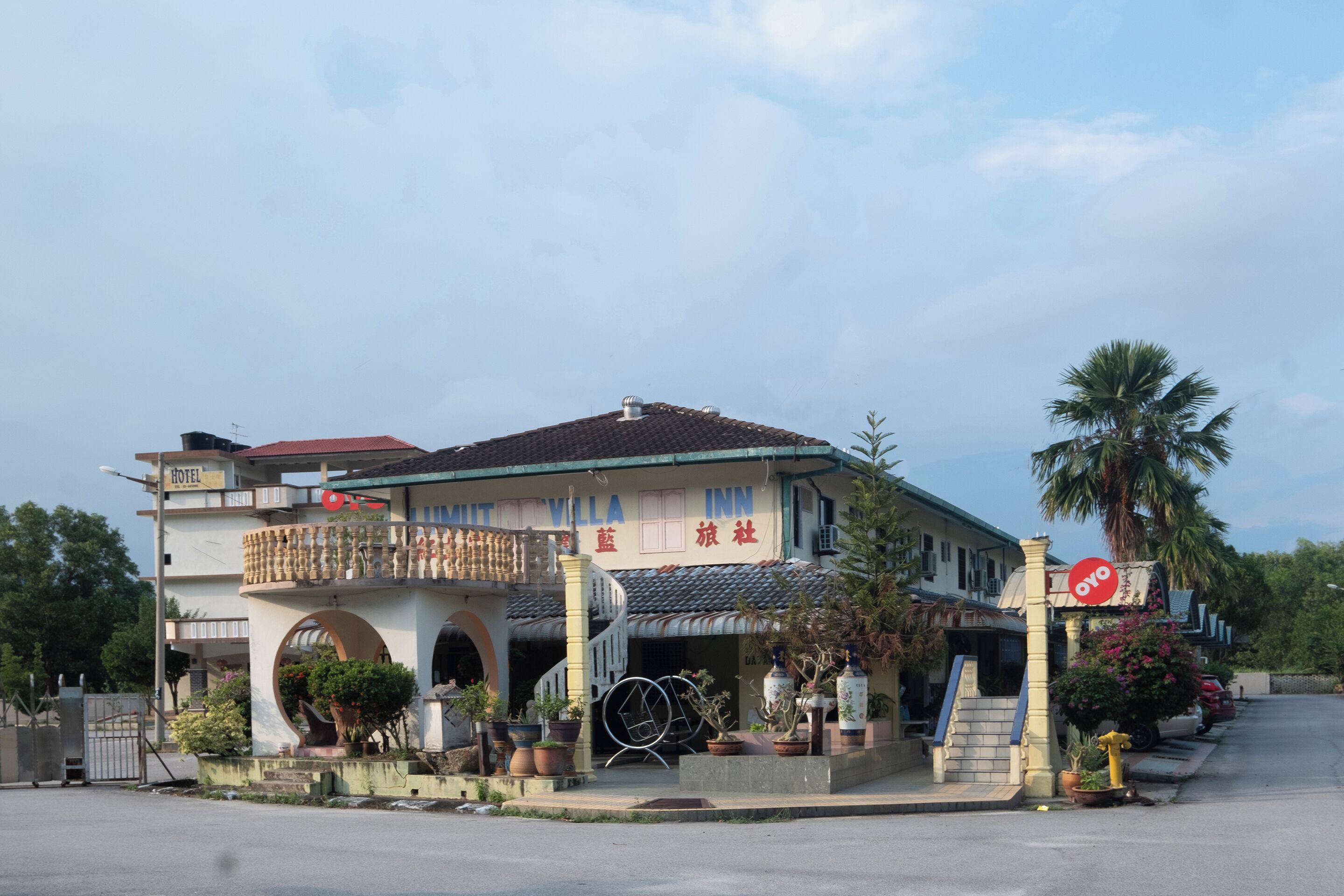 A two-story building with a balcony, a staircase, and a sign indicating it is a hotel.