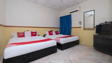 A hotel room with two beds, each with red and white bedding and pillows, a blue curtain, a flat-screen TV, and a tiled floor.