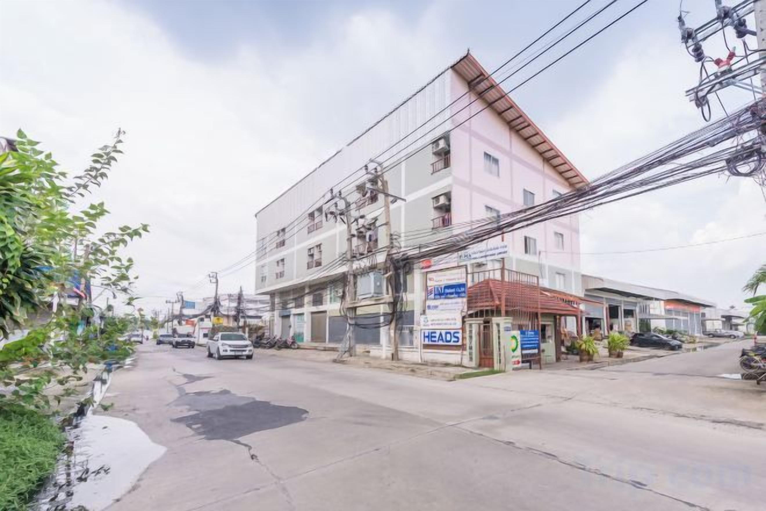 A multi-story building with a commercial ground floor, power lines overhead, and a street in front.