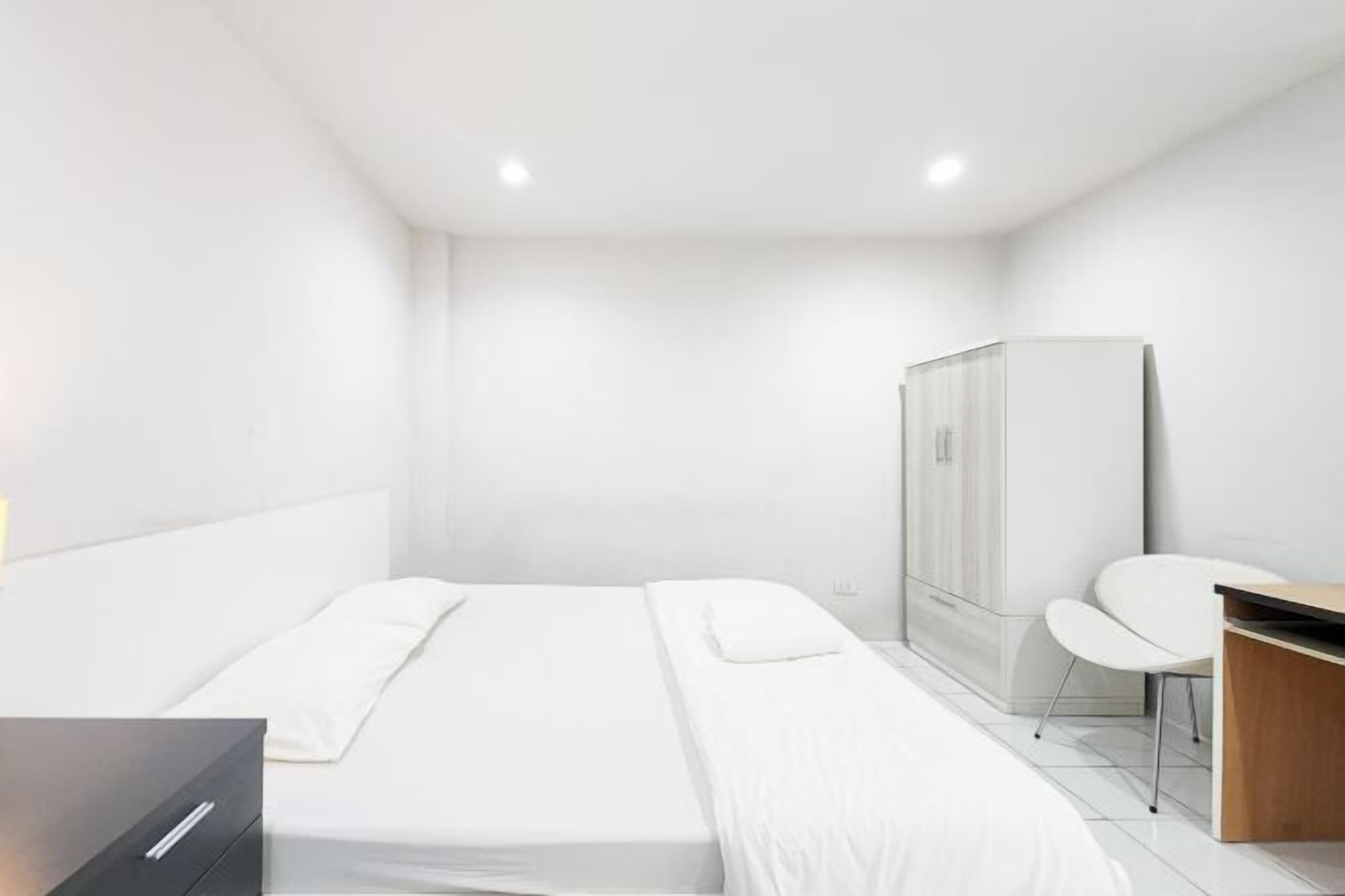 Une chambre d’hôtel moderne équipée d’un lit, d’un bureau et d’une armoire.