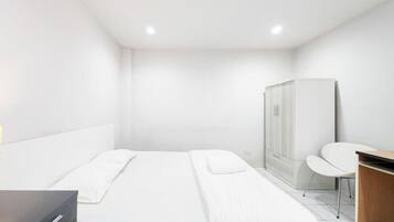 Une chambre d’hôtel moderne équipée d’un lit, d’un bureau et d’une armoire.