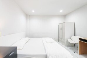 A modern hotel room with a bed, a desk, and a wardrobe. - Freesia Bangphi Guest House (Bang Phli)