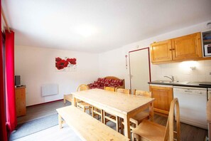A compact kitchen with wooden cabinets, a sink, and a dishwasher.