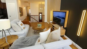 Una sala de estar moderna con un sofá, una mesa de centro y una televisión.