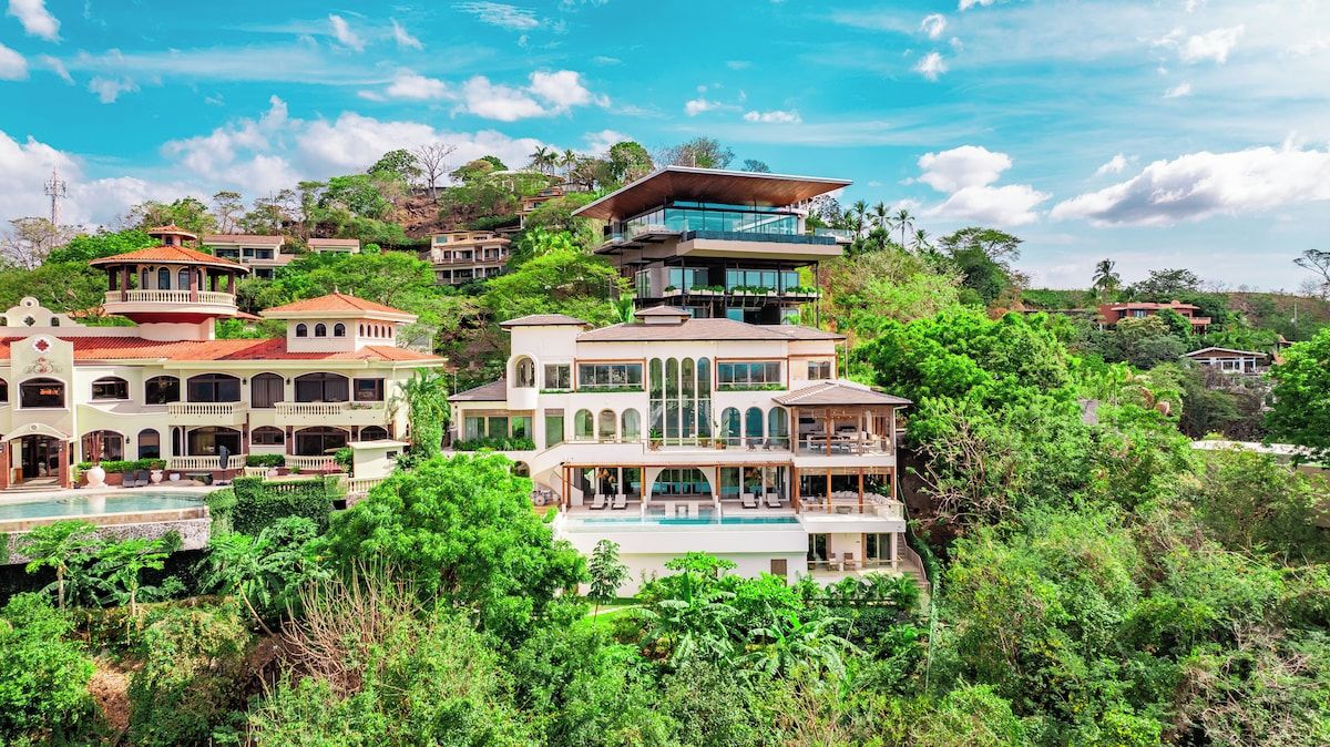 Un edificio residenziale a più piani con piscina, immerso nel verde.