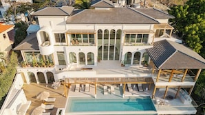 A large, modern house with a swimming pool, multiple balconies, and a covered patio area. - Ocaso Culturally Rich Villa, Flamingo Beach (Flamingo)