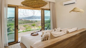 Un dormitorio con una cama grande, vistas al exterior y una lámpara colgante.