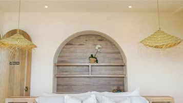 Una camera da letto con un letto, due comodini, una ventola a soffitto e due lampade a sospensione.