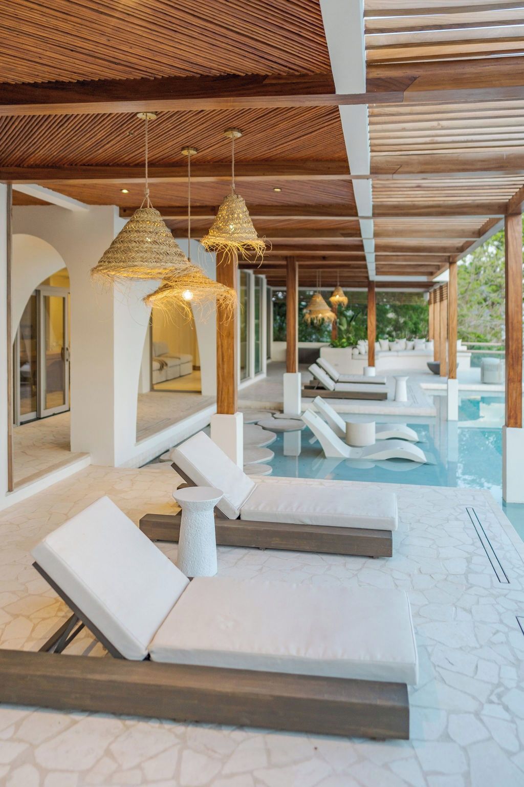 Zona junto a la piscina con sillas de descanso y una piscina.