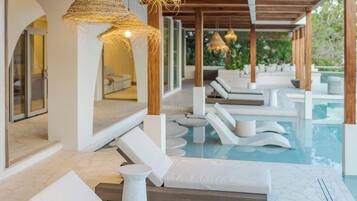 Zona junto a la piscina con sillas de descanso y una piscina.