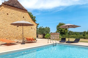 A pool area with stone walls, lounge chairs, and umbrellas. - Robin - Four Bedroom Villa, Sleeps 6 (Sainte-Alvère)