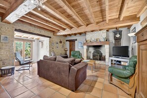 A cozy living room with a fireplace, leather sofas, a television, and a stone wall. - Robin - Four Bedroom Villa, Sleeps 6 (Sainte-Alvère)
