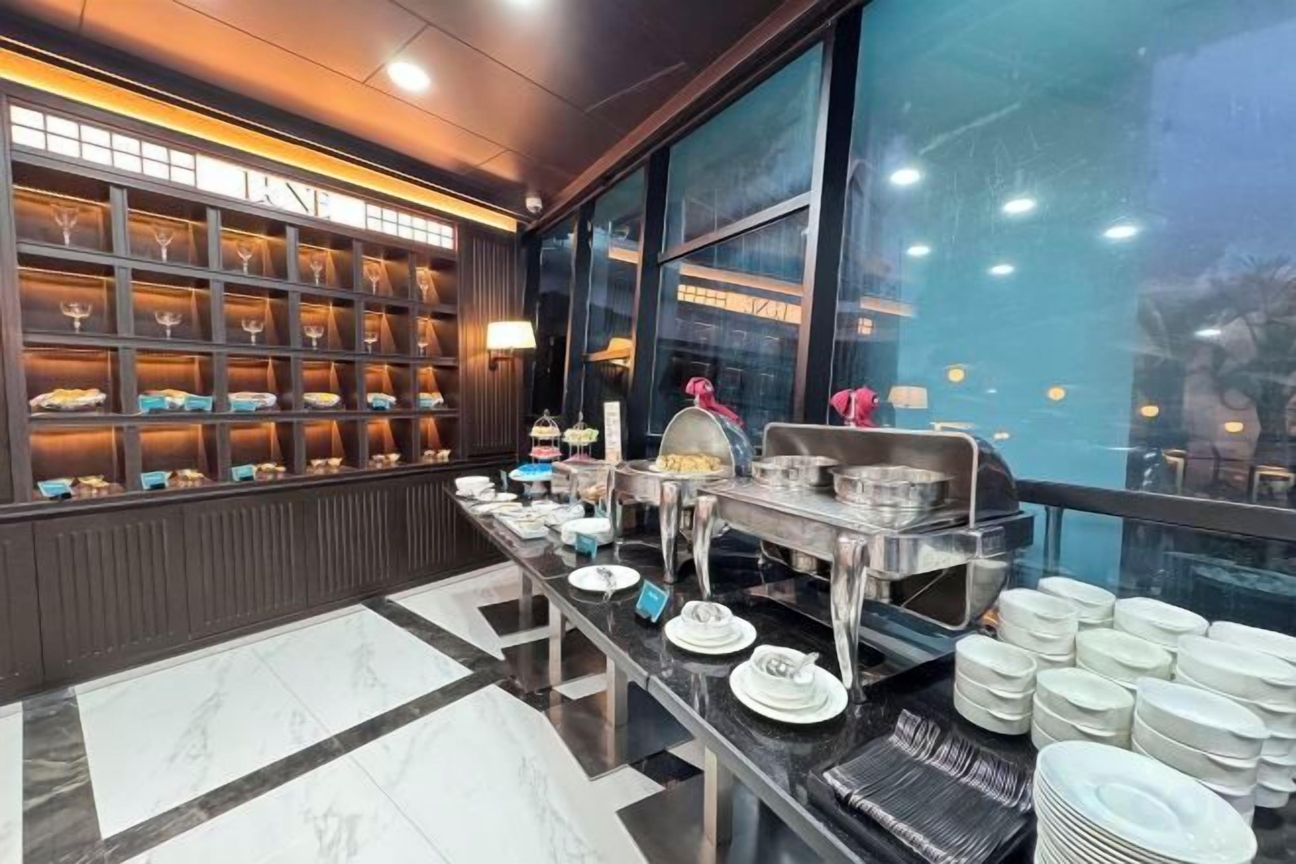 A buffet setup with a variety of dishes and a selection of glasses.