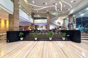 A spacious lobby with a reception desk, seating area, and a staircase leading to upper floors. - Galaxy Hotel Banjarmasin (Banjarmasin)