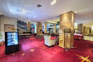 A hotel lobby with a red carpet, a reception desk, and a staircase in the background. - Galaxy Hotel Banjarmasin (Banjarmasin)