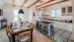Una cocina amplia con vigas de madera, una isla grande y taburetes de bar.