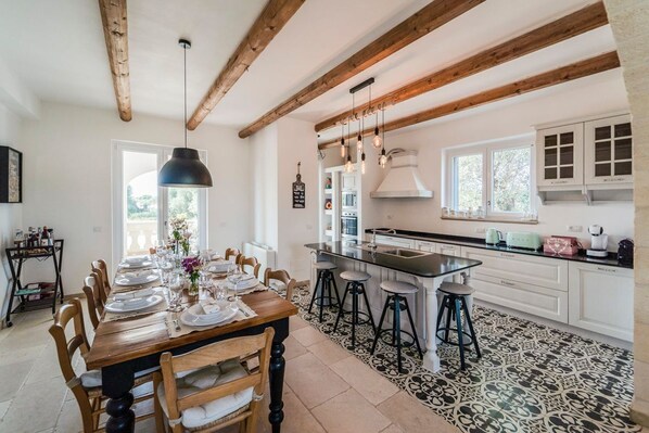 Una cocina amplia con vigas de madera, una isla grande y taburetes de bar.