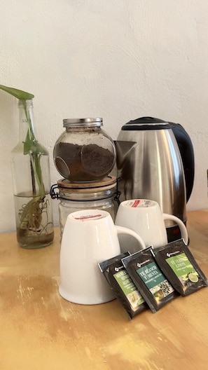 Enjoy a warm cup of tea in the comfort of your kitchen, where a coffee maker and tea packets await.