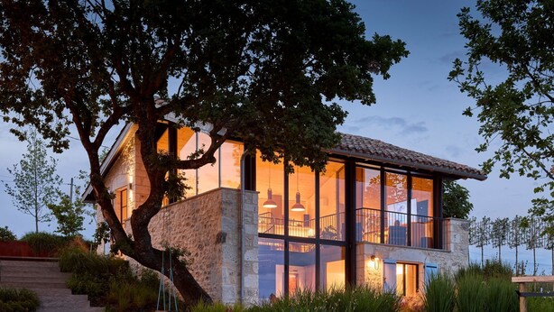 A modern house with large glass windows, a stone facade, and a tree in the foreground. - Le Grand Chene - Five Bedroom Villa, Sleeps 10 (Touffailles)