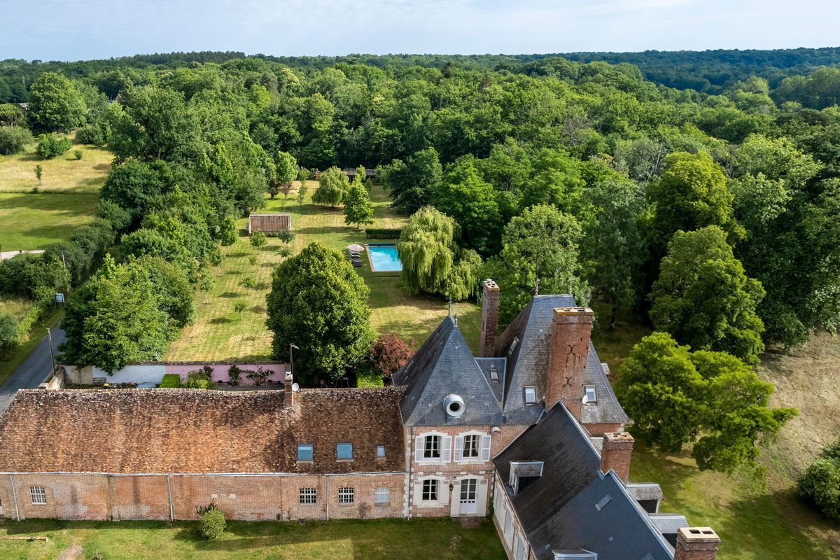 A large estate with a main building, a swimming pool, and extensive greenery.