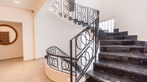 A spiral staircase with black railings and marble steps, leading to an upper floor. - Collection O Lavanda Anzures Mexico City (Mexico City)
