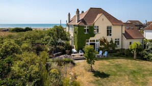 Ein zweistöckiges Haus mit Garten und Meerblick.