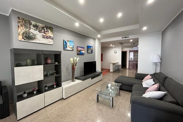 A modern living room with a sofa, coffee table, and built-in shelving.