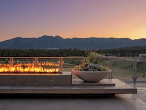 A fire feature with a flower arrangement on a balcony overlooking mountains. - Hotel Polaris (Colorado Springs)