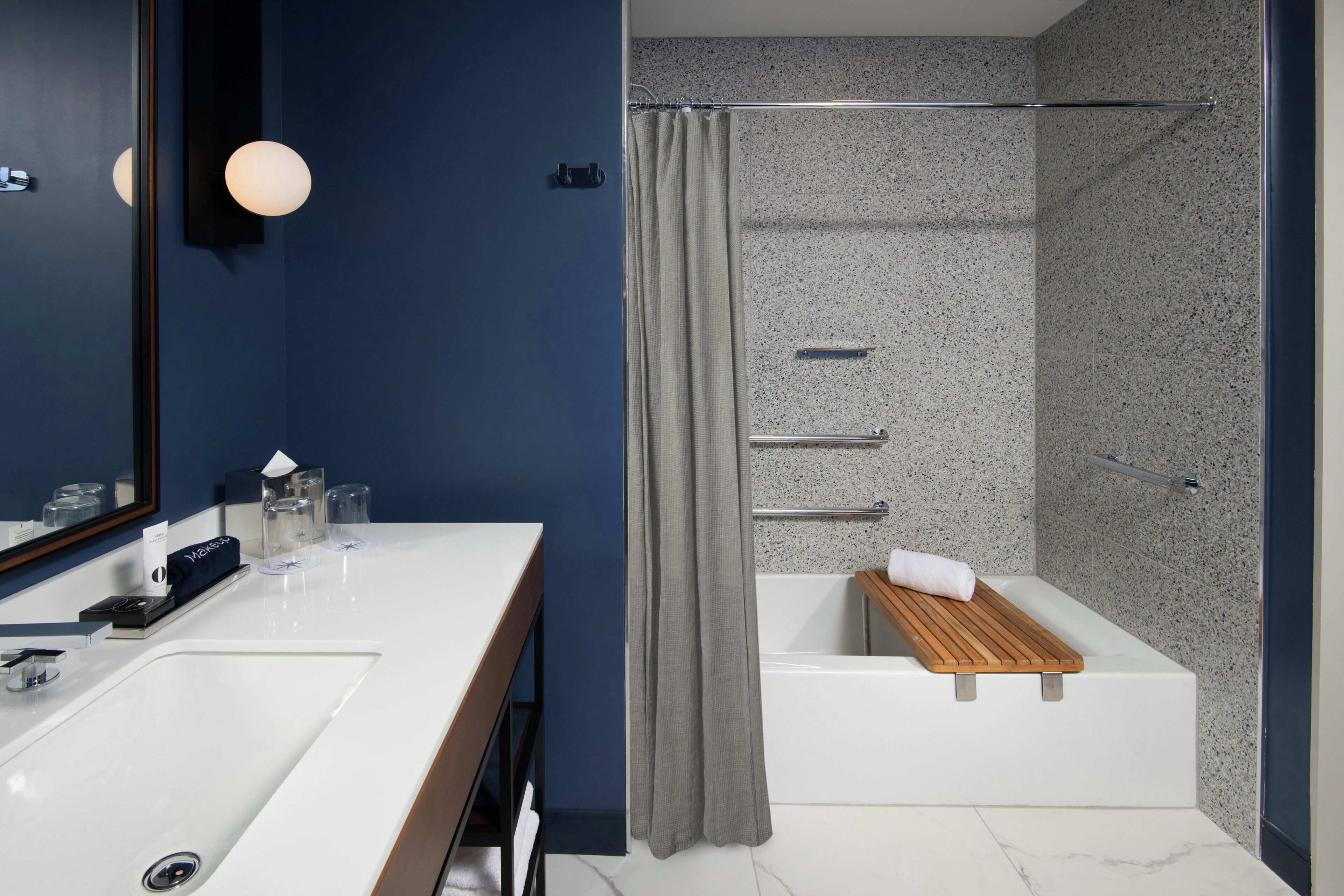 Un bagno moderno con doppio lavabo, una doccia e uno scaffale in legno nella vasca.