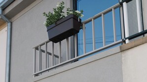 Un immeuble moderne doté d’un balcon, d’une grande fenêtre et d’une porte portant le numéro 11.