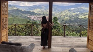 Una terraza de madera con vistas a un paisaje montañoso.