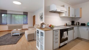 Eine moderne Küche mit Einbauofen, Kaffeemaschine und Spüle.