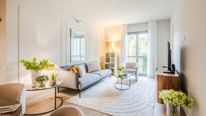 Una sala de estar moderna con un sofá, una mesa de centro y un mueble para la televisión.